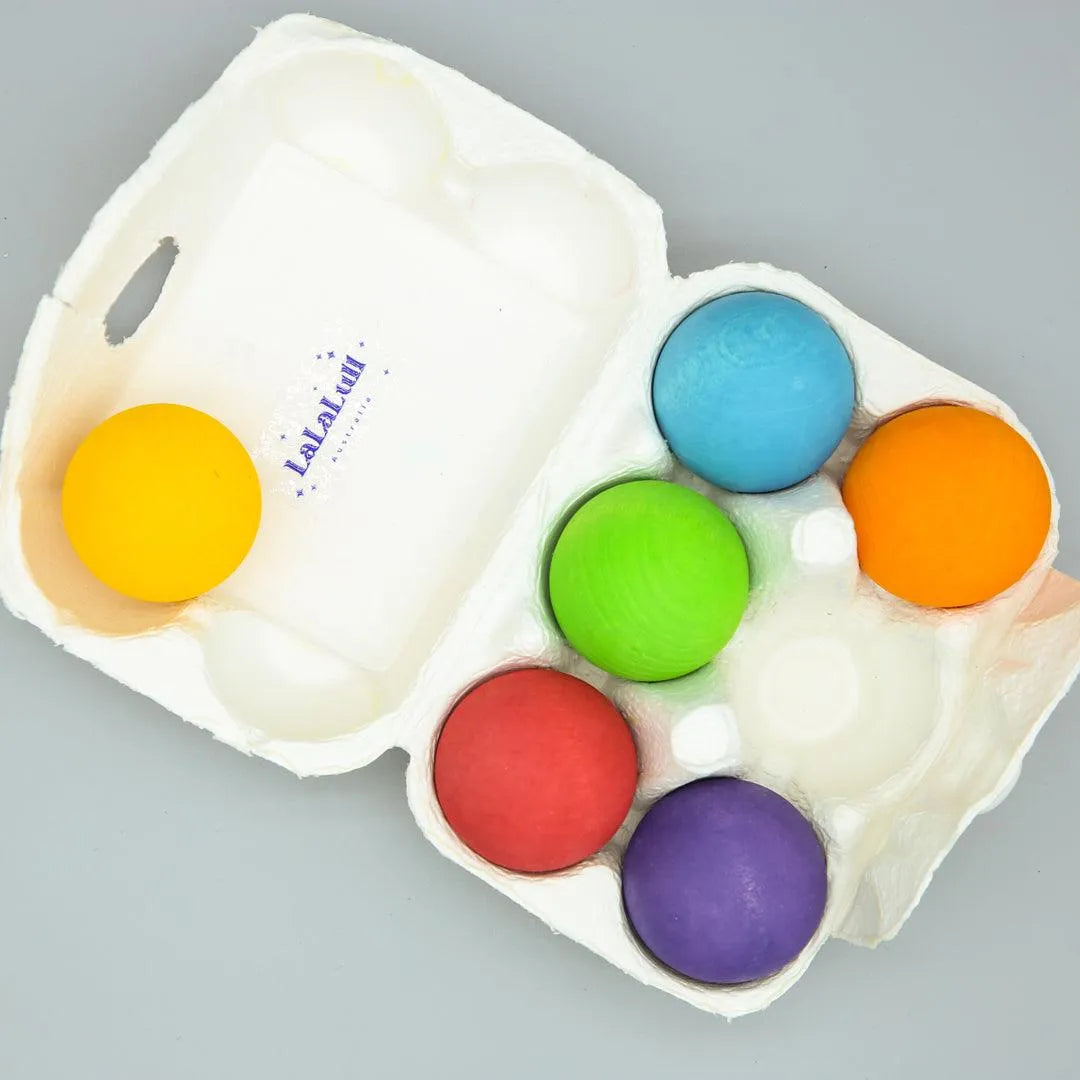 wooden rainbow balls in egg tray